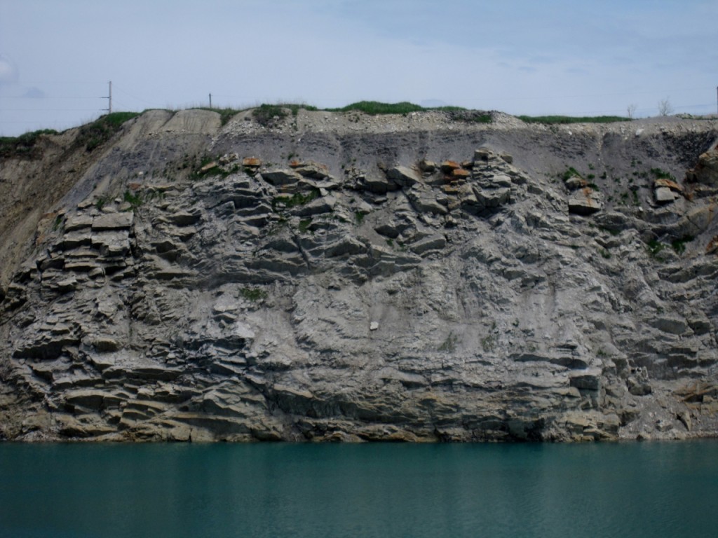 Highwall of the center east pit, glacial debris at top, Maquoketa shale, then Galena and Platteville formations.  Stata tilts sharplt eastward. Click for larger size.